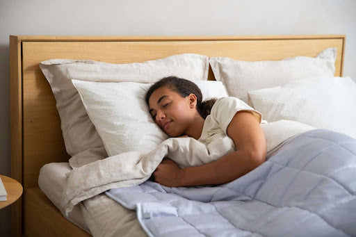 Woman sleeps under weighted blanket