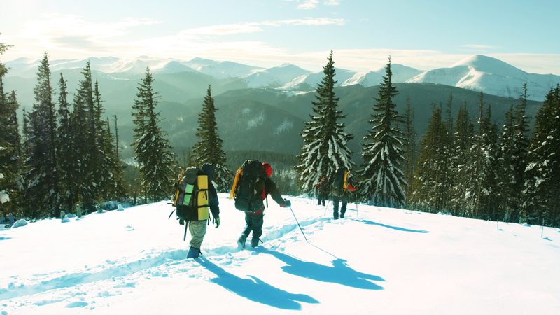 People hiking in snowy mountain terrain