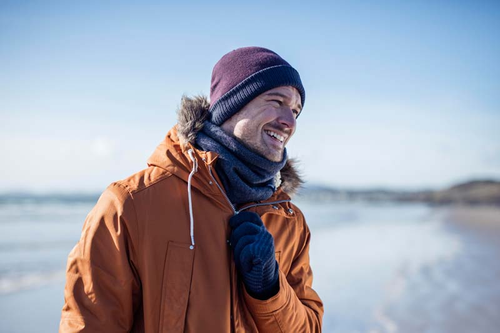 Man on beach wearing Heat Holders thermal accessories
