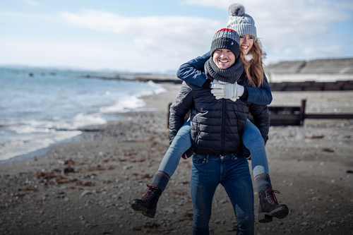 Couple on the beach wearing Heat Holders thermal products