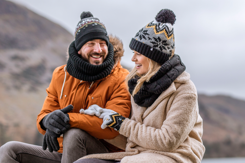 Couple wearing Heat Holders socks and accessories sitting beside a lake