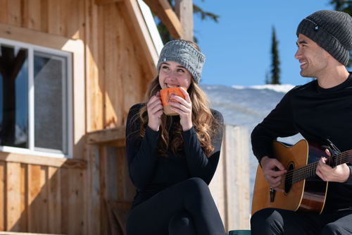 Woman sitting outside chalet wearing Heat Holders thermal baselayer