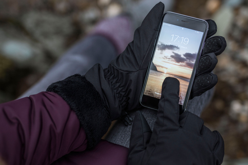 Woman operating mobile phone wearing Heat Holders women's thermal gloves